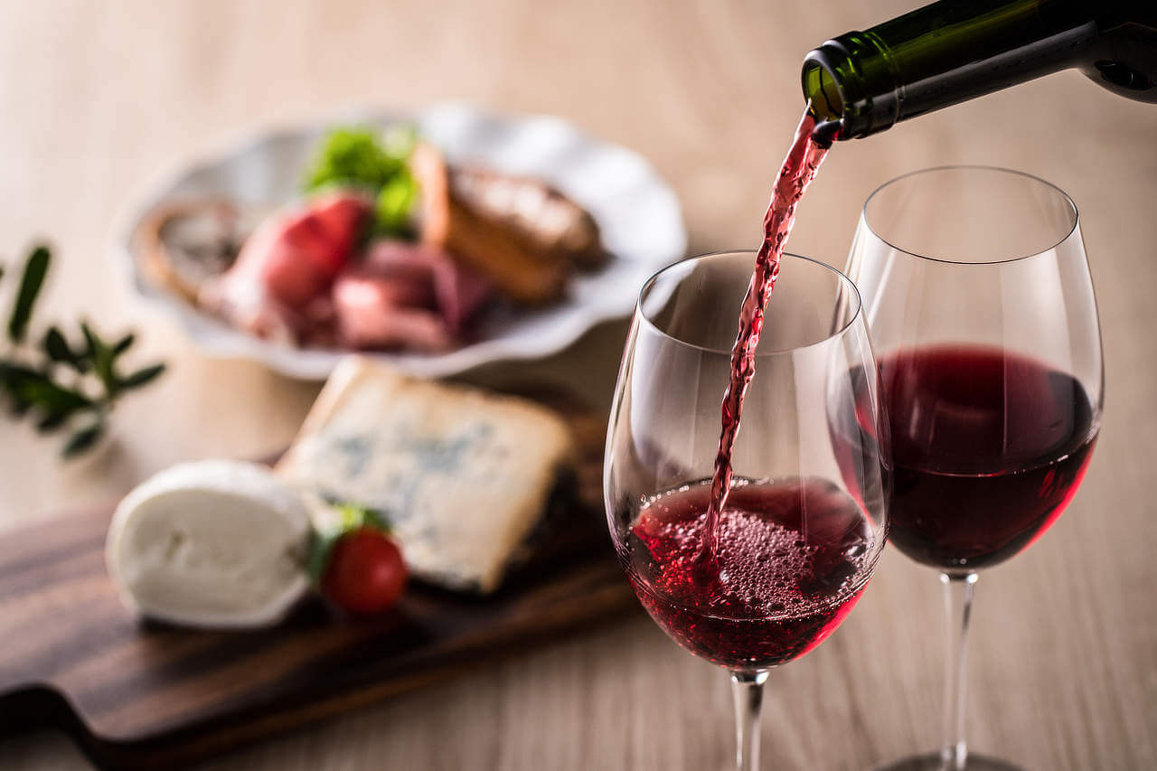 what is dry red wine - wine pouring with cheese and meats - body image
